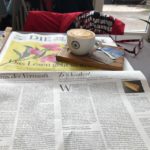 Zeitunglesen und Belohnungscappuccino im Café.
