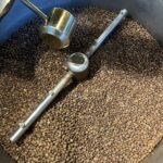 Im Café schnurrt der Röster und verbreitet leckeren Kaffeeduft.