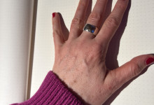 Mit den Fingern (Nägel frisch lackiert) aufs Notizbuch trommeln