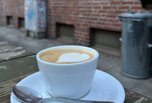 Vorm Café einen leckeren Cappuccino trinken.