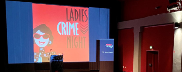 Das Word-Bildlogo der Mörderischen Schwestern ist auf eine Kinoleinwand projiziert. Eine gezeichnete Frau in rot, weiß und schwarz neben den Wortern: Ladies Crime Night.